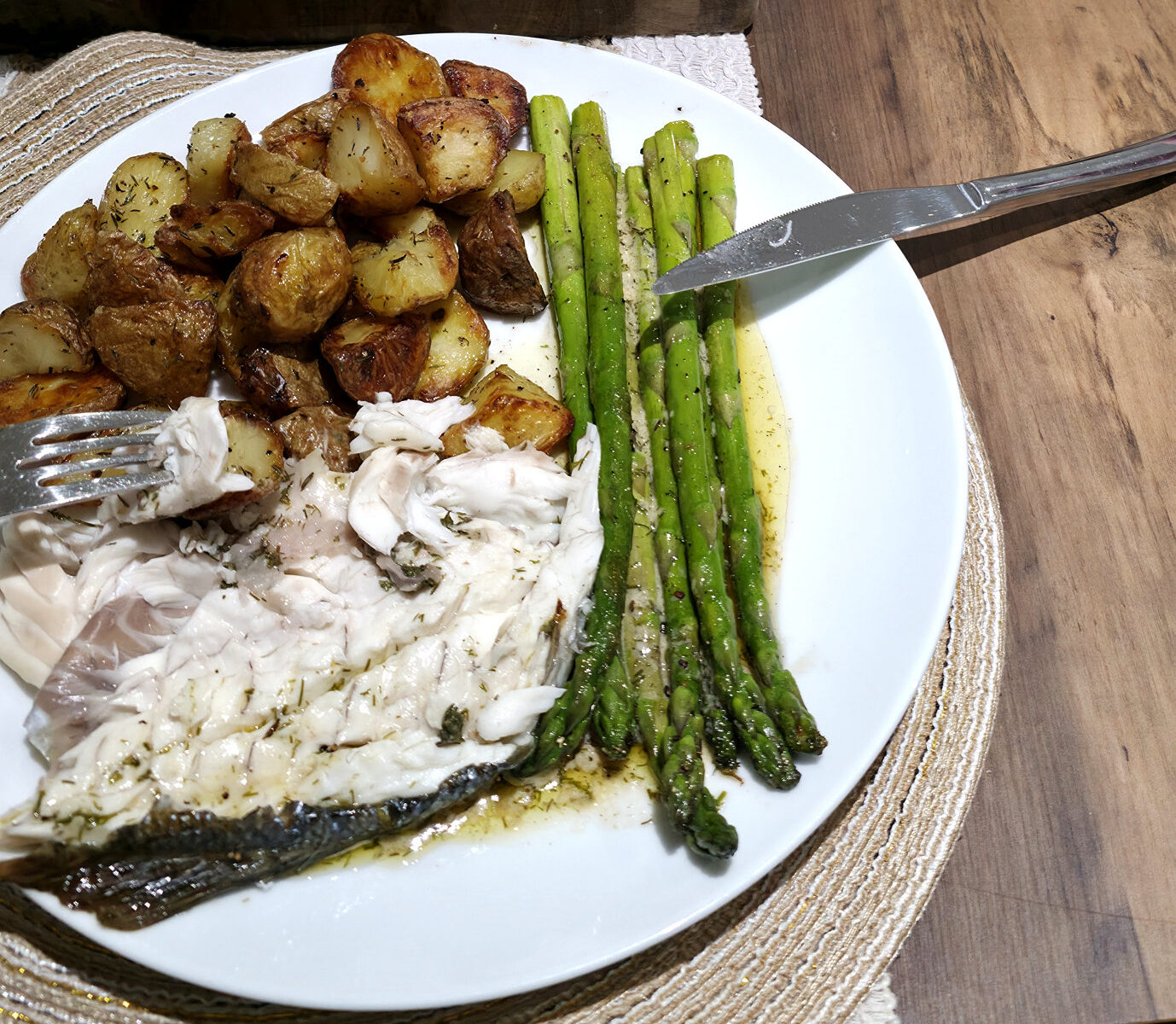 Home-cooked sea bass served with potatoes and green vegetables at the kitchen table
