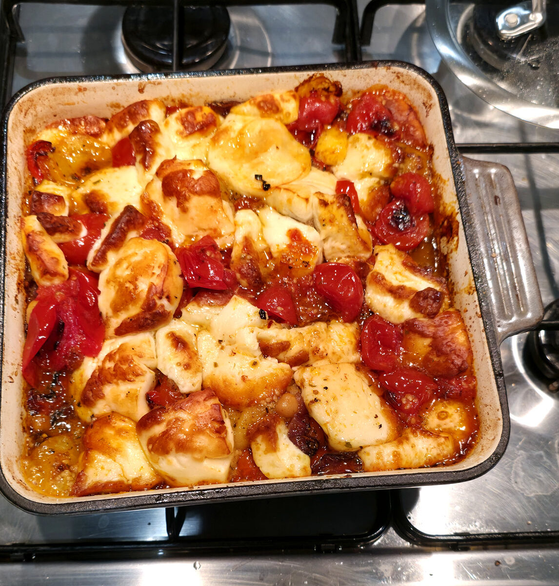 Original home-cooked halloumi traybake with golden halloumi pieces, blistered tomatoes, roasted pepper and honey dressing