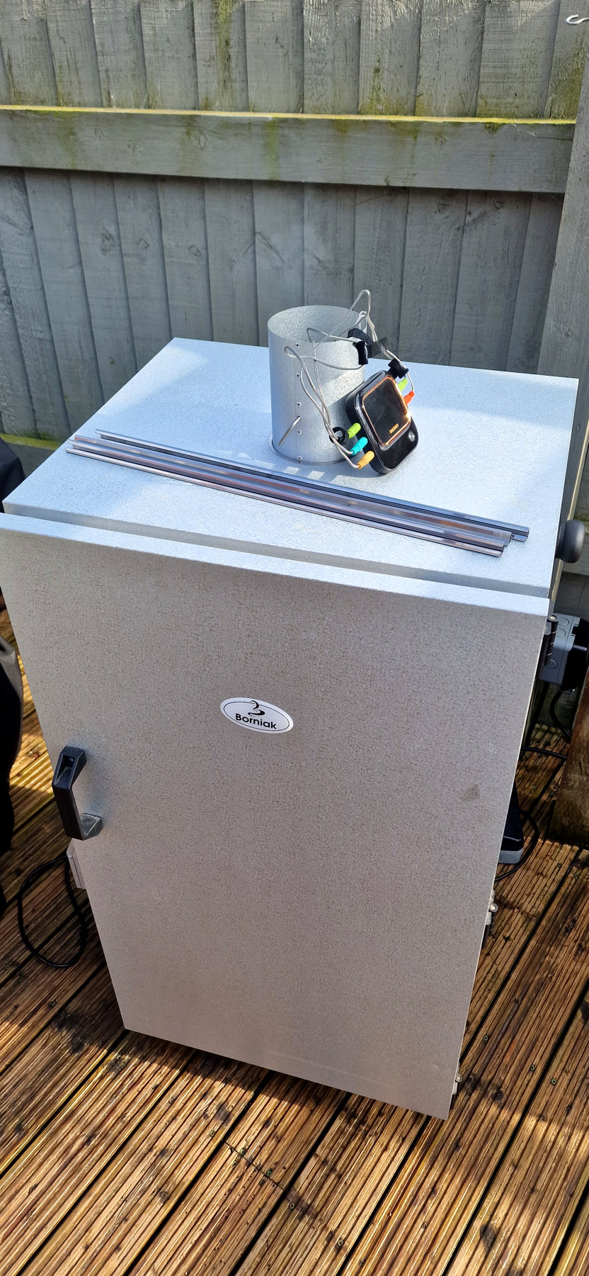 My silver Borniak UW-150 electric smoker set up on the timber deck