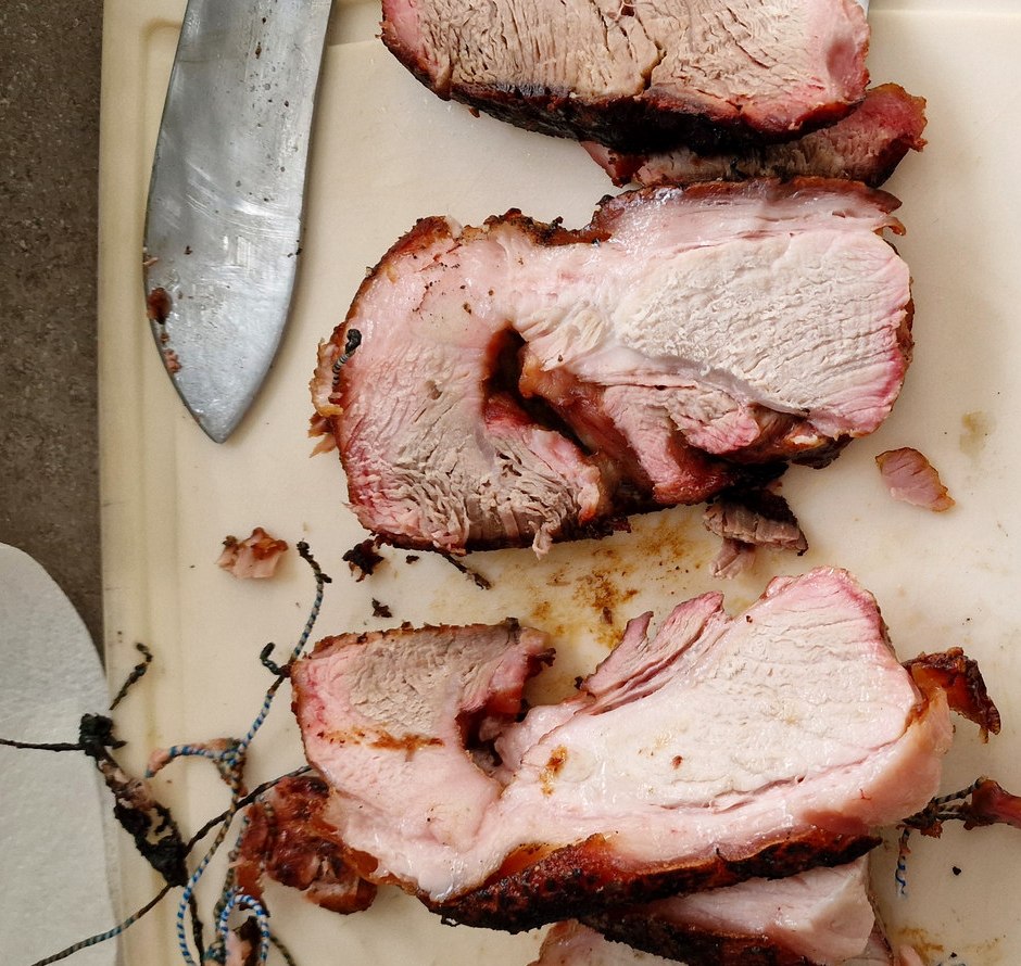 Slices of home-smoked pork with a pink outer smoke ring
