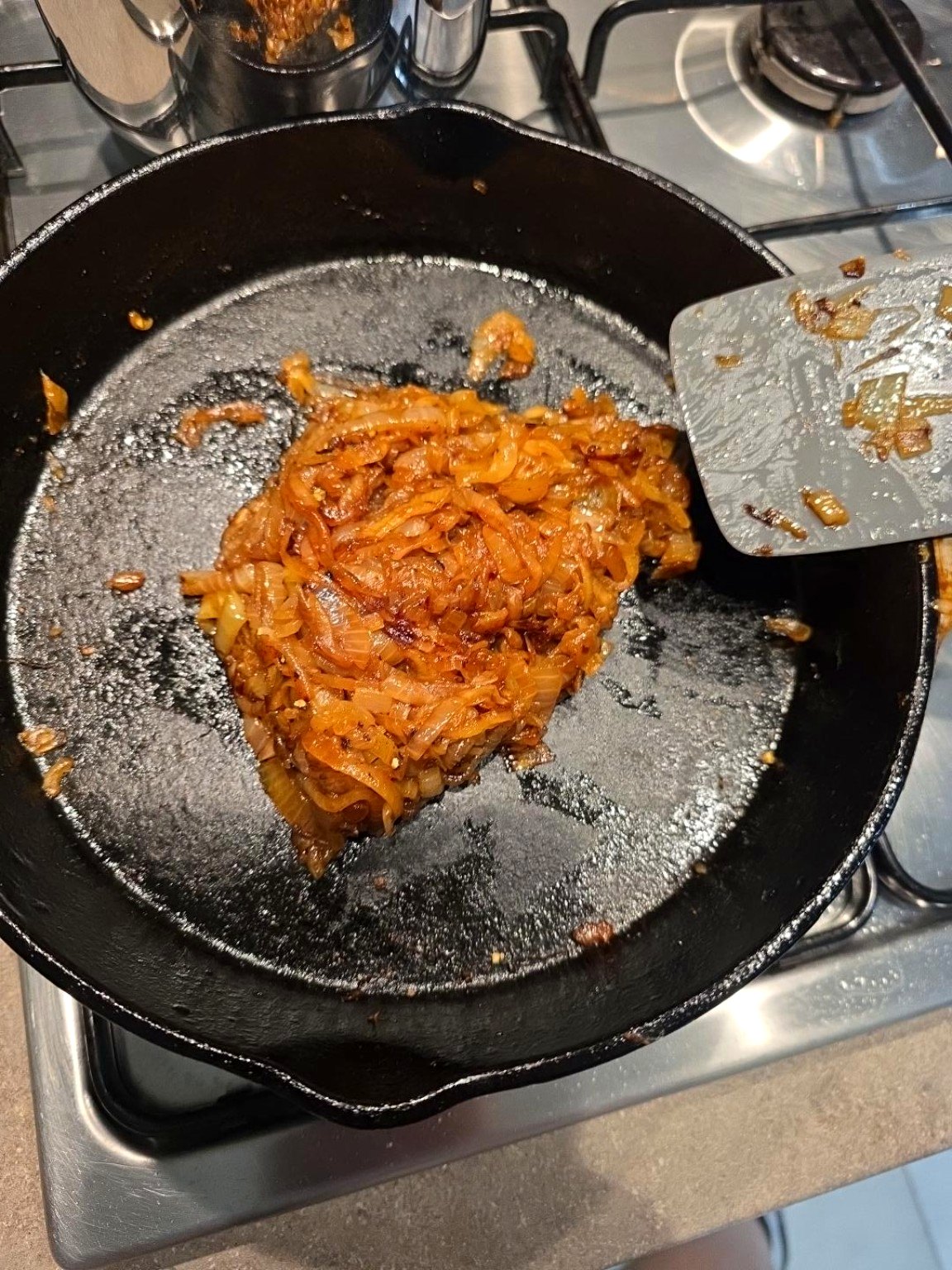 Deep golden caramelised onions cooked down to a sticky mass in cast iron