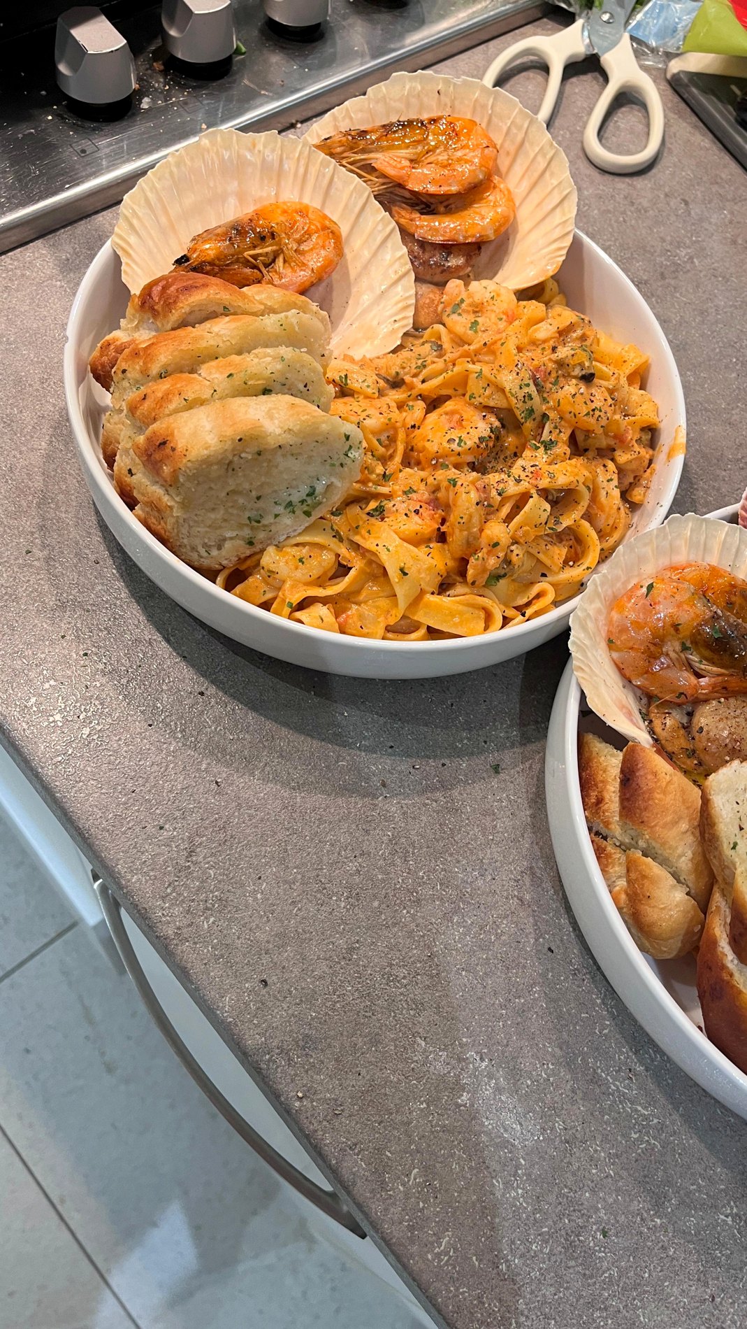 Plated tagliatelle, king prawns, scallops and garlic bread served in the user's kitchen on 4 April 2026